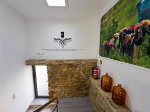 a room with a stone fireplace with a painting on the wall at Matias Nature - Mountain Lodges in Serra da Estrela, Seia in Carragozela