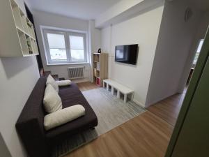 a living room with a couch and a tv at Hotel Squash House in Prievidza +10 photos