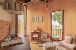 a living room with a table and chairs and a window at CABRA - Porto Covo in Porto Covo