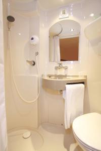 a white bathroom with a sink and a toilet at Première Classe Epernay in Épernay