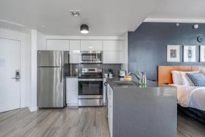 a kitchen with a counter and a bed in a room at Spacious Connecting Studios Sleeps 4 with 2 Parking Spots in Miami