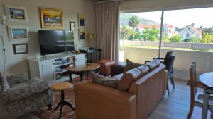 a living room with a couch and a television at The Pearl in the Winelands in Paarl