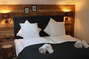ein Schlafzimmer mit einem schwarz-weißen Bett und weißen Kissen in der Unterkunft Typically Swiss Hotel Ermitage in Kandersteg