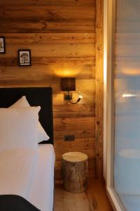 1 dormitorio con cama y pared de madera en Typically Swiss Hotel Ermitage, en Kandersteg