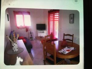 タルブにあるCharmante petite maisonのテーブルとダイニングルームのあるリビングルーム