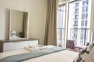 a bedroom with a mirror and a bed and a balcony at Reem Island Modern 1BR Pool, Gym, City View in Abu Dhabi +34 photos