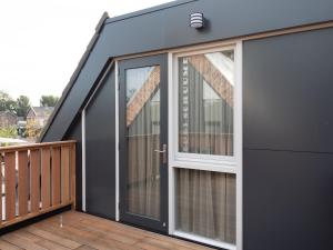 a house with sliding glass doors on a deck at Luxury apartment in Renesse with infrared sauna in Renesse