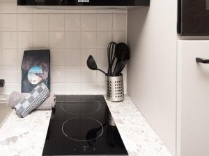 a kitchen counter with a stove with utensils at Luxury apartment in Renesse with infrared sauna in Renesse +33 photos
