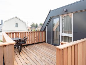 Una terraza de madera con una mesa y sillas. en Luxury apartment in Renesse with infrared sauna, en Renesse