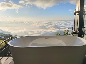 a bath tub on a balcony with a view of clouds at ไร่ผางาม ภูทับเบิก in Ban Maeo Thap Boek