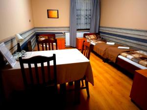 une chambre avec deux lits, une table et des chaises dans l'établissement K14 Rooms Lublin, à Lublin