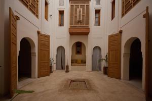 un pasillo vacío de un edificio con puertas de madera en Riad Al Muhandiz Peaceful Duplex Suites near Jemaa El Fna, en Marrakech