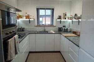 a kitchen with white cabinets and a sink at 2 Bed Cottage Sleeps 4 -Private Garden -Pets Okay in Blairgowrie