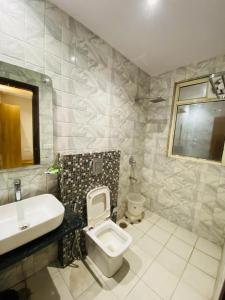 a bathroom with a toilet and a sink at Hotel Sehej Continental At Karol Bagh in New Delhi +22 photos