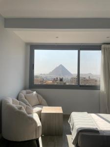 a bedroom with a view of a mountain through a window at Legend Pyramids Inn in Cairo