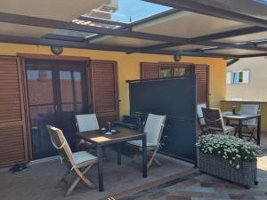 a patio with a table and chairs and a screen at Apartments CLIFF Piran in Piran