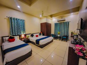a hotel room with two beds and a television at Hotel Paradise inn in Udaipur