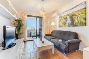 Una sala de estar con un sofá y un televisor. en Playa Paraiso, en Playa Paraiso