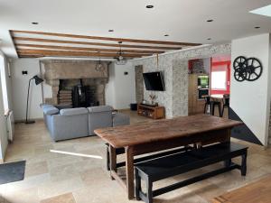 a living room with a wooden table and a couch at Maison de La Rive in Ploëzal