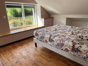 a bedroom with a bed and a window at Maison de La Rive in Ploëzal