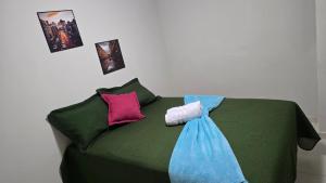 a green couch with towels and pictures on the wall at Flats 1778 N102 Orla de PETROLINA in Petrolina