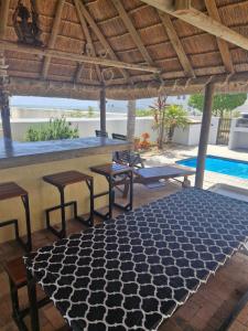 a patio with a table and a bar with stools at Beachway on Golden Mile in St. Helena Bay