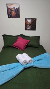 a green bed with towels and pictures on it at Flats 1778 N102 Orla de PETROLINA in Petrolina