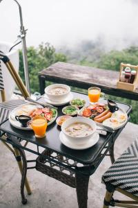 ein Tisch mit Tellern mit Essen und Getränken darauf in der Unterkunft Sinsup villa Doichang 2 in Ban Huai Khai