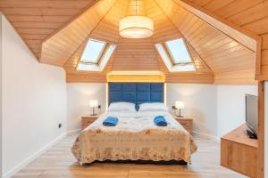 a bedroom with a large bed with wooden ceilings at Pokoje Marta in Międzybrodzie Bialskie
