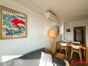 a room with a bed and a table and a painting of a tsunami at El Apartamento in Benicàssim