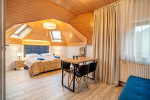 a bedroom with a bed and a desk with a table at Pokoje Marta in Międzybrodzie Bialskie