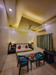 a bedroom with a bed and two blue chairs at Hotel Paradise inn in Udaipur