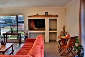 a living room with a red couch and a table at The Loft in Gansbaai