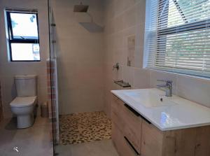a bathroom with a sink and a toilet and a window at The Loft in Gansbaai +9 photos