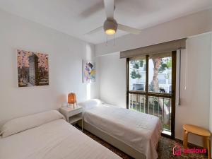 two beds in a room with a window at El Apartamento in Benicàssim +39 photos