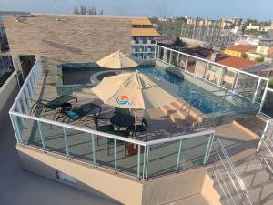 una vista aérea de una piscina con mesas y sombrillas en Flat com Hidromassagem Privativa no Centro De Porto de Galinhas - Sol e Mar Residence, en Porto de Galinhas