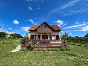 a small house in a field with a blue sky at Diófás Ház in Siklós