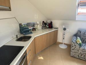a small kitchen with a sink and a fan at Ático La Quinta Esencia in Negreira
