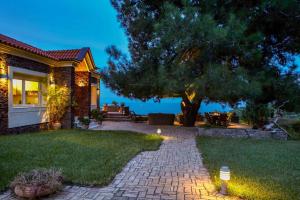 a house with a tree and a brick driveway at Villa Laurette Kratigos - Private Escape with Views in Pligónion