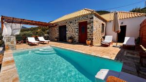 a villa with a swimming pool in front of a house at Cassiopea Guest House Evia Greece in Nerotriviá