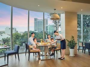 a family sitting at a table in a dining room at Novotel Saigon Centre in Ho Chi Minh City +93 photos