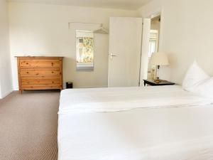 a bedroom with two white beds and a dresser at Vully Panorama Apartment 3 Schlafzimmer nahe Bern in Zollikofen