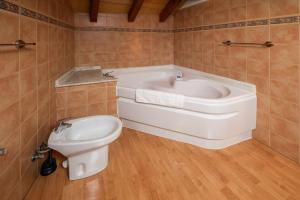 ein Badezimmer mit Badewanne, Toilette und Waschbecken in der Unterkunft Casa la Encina de Pancar in Pancar + 34 Fotos