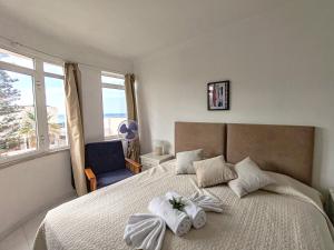 a bedroom with a bed with white sheets and a window at 4C Atlantico 1 - Casas & Papeis in Armação de Pêra