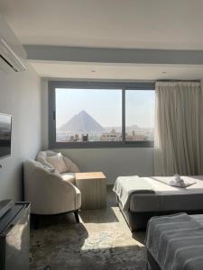 a bedroom with a bed and a view of a mountain at Legend Pyramids Inn in Cairo