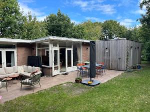 a patio with a table and chairs in a yard at Fraaie familiebungalow op heerlijk rustige plek in Ouddorp