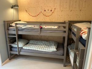 a bunk room with three bunk beds in it at Fraaie familiebungalow op heerlijk rustige plek in Ouddorp +28 photos