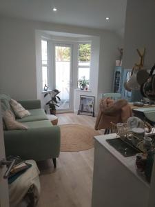 a living room with a green couch and a fireplace at Beautiful flat in the heart of South London in London