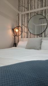 a bedroom with a bed with a mirror and a lamp at Beautiful flat in the heart of South London in London
