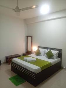 a bedroom with a large bed with green pillows at Mid City Apartment in Badulla +8 photos